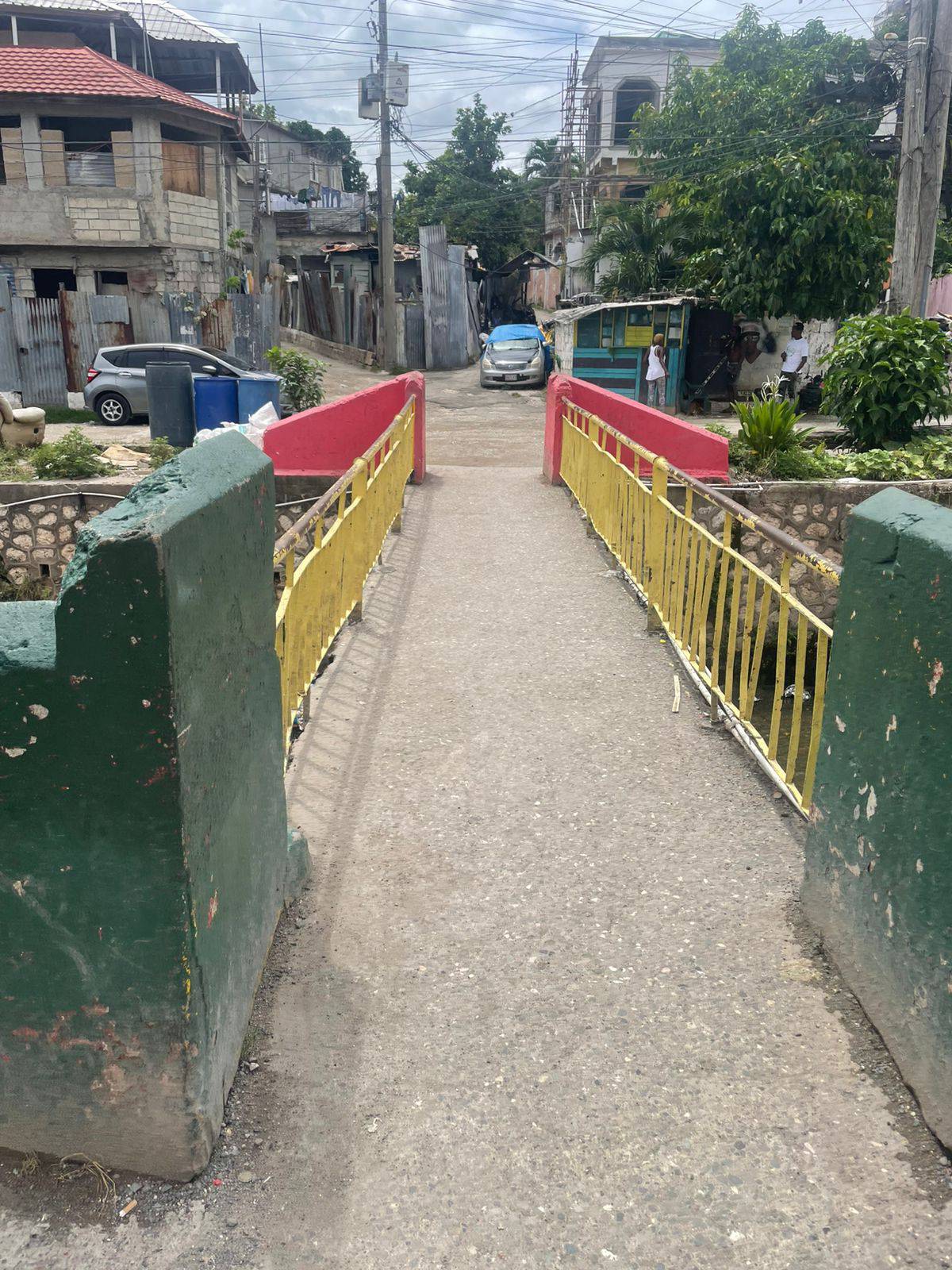 The bridge in Cassava Piece, Kingston — where Joey Brooks grew up, with green, yellow, and red walls leading into the community